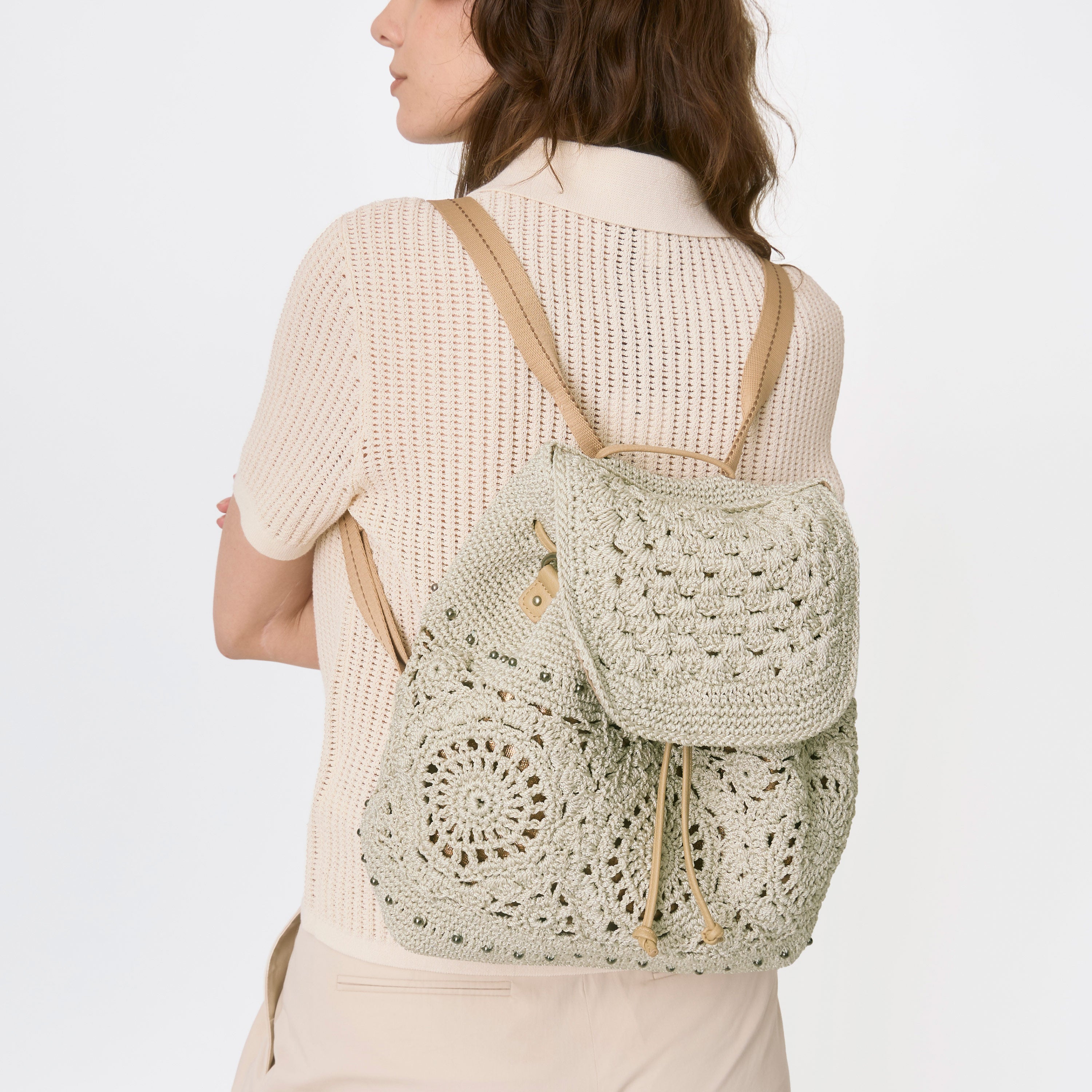brown faux leather backpack with ivory floral crochet overlay The Sak Sayulita Backpack - Hand Crochet